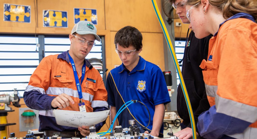 Abbot Point Operations Fourth Year Engineering (Fitting and Turning) Apprentice Bryce Doyle instructs Bowen State High School students at the QMEA's Tradie for a Day workshop; Image Source: Supplied