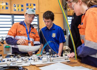 Minerals Academy workshop hammers home opportunities for future tradies Abbot Point Operations Fourth Year Engineering (Fitting and Turning) Apprentice Bryce Doyle instructs Bowen State High School students at the QMEA's Tradie for a Day workshop; Image Source: Supplied