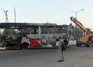 A damaged bus being removed after a clash broke out, in Haryana's Nuh on Tuesday. A violent clash erupted between two groups during the Hindu procession. (ANI Photo)