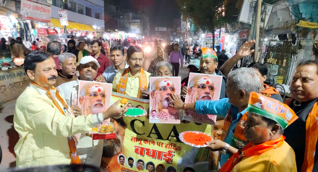 Activists celebrate after Central Government announced the notification of the rules to implement the Citizenship Amendment Act, at Kodai Chowki, in Varanasi; Image Source: (ANI Photo)