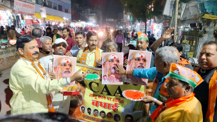 Activists celebrate after Central Government announced the notification of the rules to implement the Citizenship Amendment Act, at Kodai Chowki, in Varanasi; Image Source: (ANI Photo)