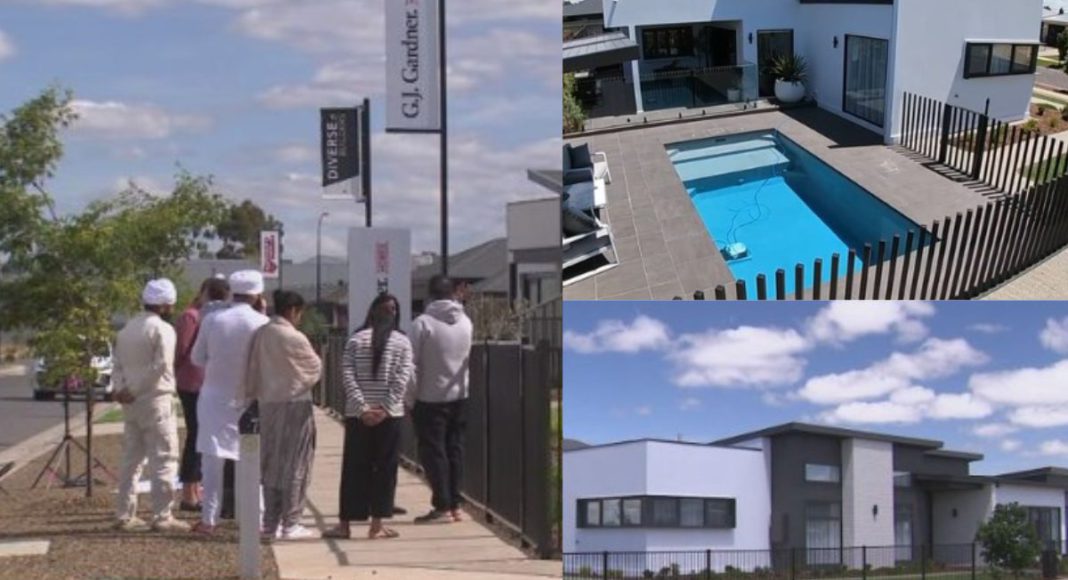 Image: A family gathered at the Kialla display home where emergency services were called to reports of a boy found unresponsive in a swimming pool (Source: Nine News screenhots)