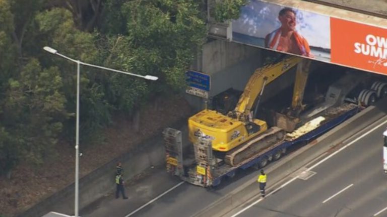 Truck carrying excavator causes chaos after hitting two Melbourne bridges