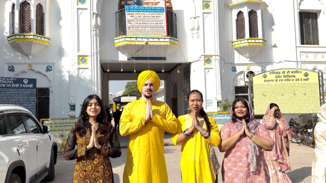 Image: Looking radiant in yellow traditional attire Raoul Galea and Worakamon Chardcharoen with students from the School of Journalism and Mass Communication, Chitkara University, in from of the Gurudwara. (Source: Supplied)